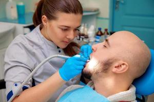 femme dentiste avec un patient masculin photo