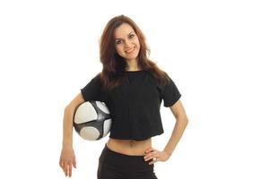 une jeune fille joyeuse dans une chemise de sport tient le ballon et sourit photo