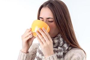 jeune fille tenant une tasse de thé à la main et boit en gros plan photo