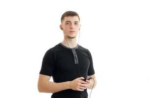 beau jeune homme en chemise noire a l'air droit et tient un téléphone photo