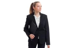 une belle jeune femme d'affaires sérieuse debout dans un costume noir et tenant une tablette photo