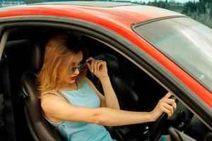 glamour jeune fille au volant de voiture de sport photo