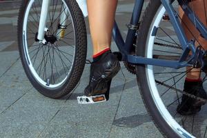 la photo en gros plan des jambes en baskets à vélo