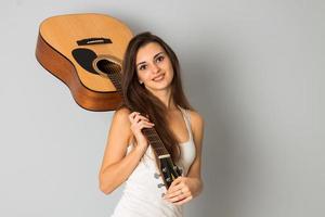 femme brune avec une guitare dans les mains photo