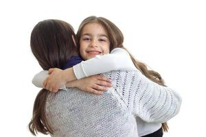 petite fille sourit et embrasse sa mère en gros plan photo