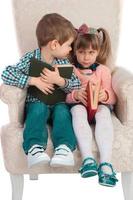 les enfants sont assis sur une chaise avec des livres photo