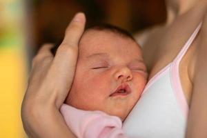 petite fille dort dans les mains de sa mère photo