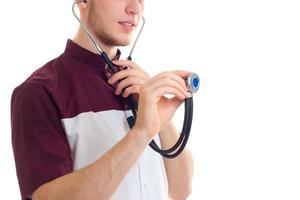 jeune médecin tenant un stéthoscope et vérifie qu'il fonctionne en gros plan photo