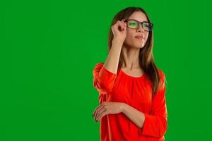 femme à lunettes sur fond vert regardant loin photo