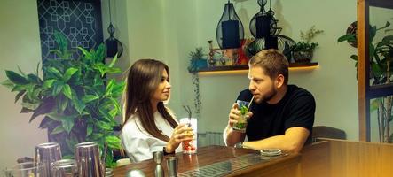 jeune couple amoureux boit un cocktail et flirte photo