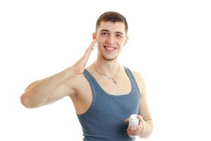 un beau mec souriant attend avec impatience et traite le gros plan de la mousse à raser le visage photo