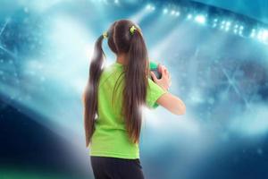 fille en chemise verte avec ballon de foot photo
