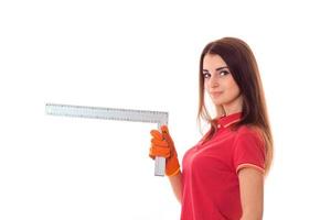 jeune femme mignonne aux cheveux noirs en uniforme fait des rénovations avec des outils dans ses mains isolé sur fond blanc photo