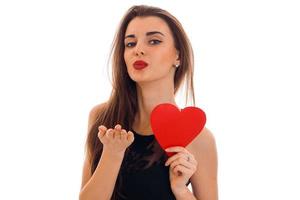 jeune femme charmante aux lèvres rouges se préparant à célébrer la Saint Valentin avec le symbole du coeur en studio isolé sur fond blanc photo