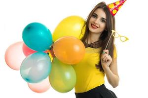 belle jeune fille souriante avec du rouge à lèvres garde beaucoup de ballons et de verres à la main photo