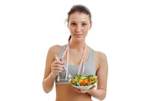 portrait d'une belle jeune fille avec une salade de légumes dans les mains photo