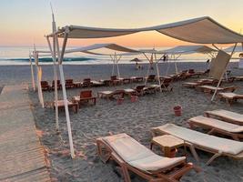 Chaises longues et parasol avec parasols sur la plage sur la mer en vacances dans un pays tropical de l'Est chaud touristique Southern Resort photo