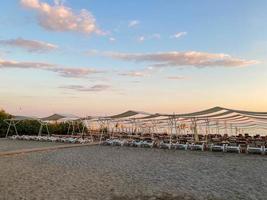 Chaises longues et parasol avec parasols sur la plage sur la mer en vacances dans un pays tropical de l'Est chaud touristique Southern Resort photo