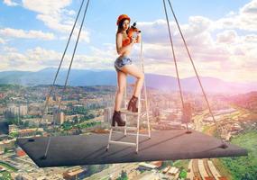 constructeur en casque debout sur une échelle avec une perceuse dans les mains photo