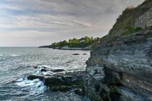 le cliffwalk à newport offre des vues sur l'arrière-cour de manoirs célèbres d'un côté et une magnifique côte rocheuse de l'autre à newport, rhode island, états-unis. photo