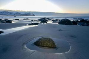 plage de vikten dans les îles lofoten, norvège en hiver au coucher du soleil. photo