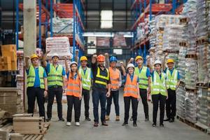 usine ou ingénieur de groupe hommes et femmes ont levé le poing droit debout avec confiance et succès. personnes travaillant sur le lieu de travail de l'usine industrielle d'entrepôt. carrière d'industrie d'entrepôt. photo