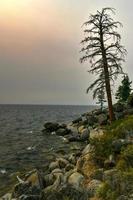 crique secrète le long du lac tahoe au nevada avec un ciel brumeux en raison des incendies de forêt à proximité en californie. photo