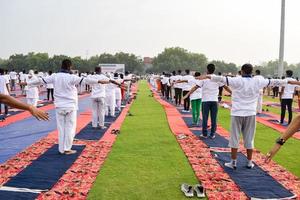 séance d'exercices de yoga en groupe pour les personnes de différents groupes d'âge au stade de cricket de delhi lors de la journée internationale du yoga, grand groupe d'adultes assistant à une séance de yoga photo