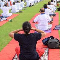 séance d'exercices de yoga en groupe pour les personnes de différents groupes d'âge au stade de cricket de delhi lors de la journée internationale du yoga, grand groupe d'adultes assistant à une séance de yoga photo