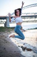 fille marchant sur la plage, contre le coucher du soleil. photo