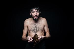 jeune homme avec portefeuille vide sur fond noir photo