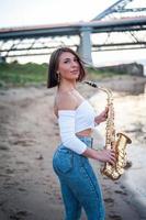 femme jouant du saxophone au coucher du soleil. photo