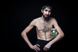 jeune homme avec une bouteille d'argent sur fond noir photo