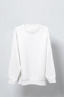 sweat-shirt blanc vierge suspendu à un cintre sur fond gris photo