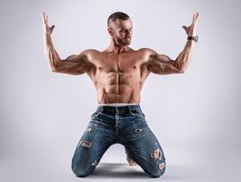 bel homme musclé portant des jeans posant en studio photo