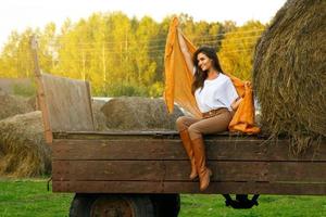 jeune femme et chariot avec des meules de foin dans le village photo