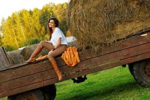 jeune femme et chariot avec des meules de foin dans le village photo