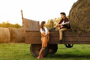 jeune couple au village. guy joue de la guitare pour sa petite amie. photo