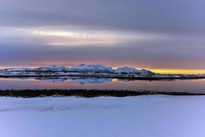 lever du soleil sur hestnesbukta sur l'île de vestvagoy dans les îles lofoten, norvège en hiver. photo