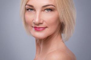 portrait d'une belle femme d'âge moyen en studio sur fond gris photo