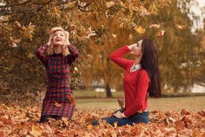 deux belles filles amies s'amusant dans le parc d'automne photo