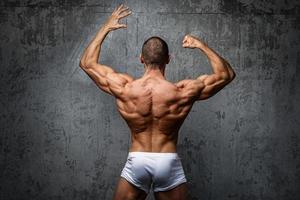 homme sexy et musclé posant contre un mur de béton photo