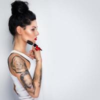 femme tatoueuse avec une machine à tatouer à la main photo