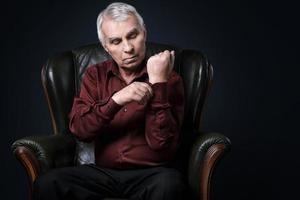 portrait d'un homme âgé sérieux dans un fauteuil photo