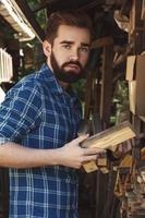 bel homme barbu avec des bois de chauffage dans le village photo