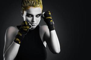 femme mma fighter aux cheveux jaunes en studio photo