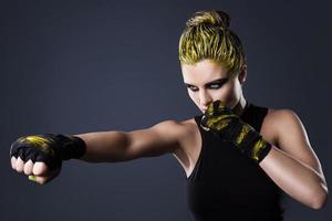 femme mma fighter aux cheveux jaunes en studio photo