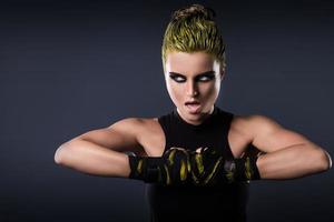 femme mma fighter aux cheveux jaunes en studio photo