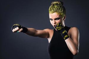 femme mma fighter aux cheveux jaunes en studio photo