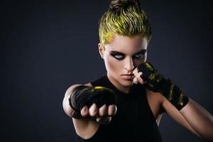 femme mma fighter aux cheveux jaunes en studio photo
